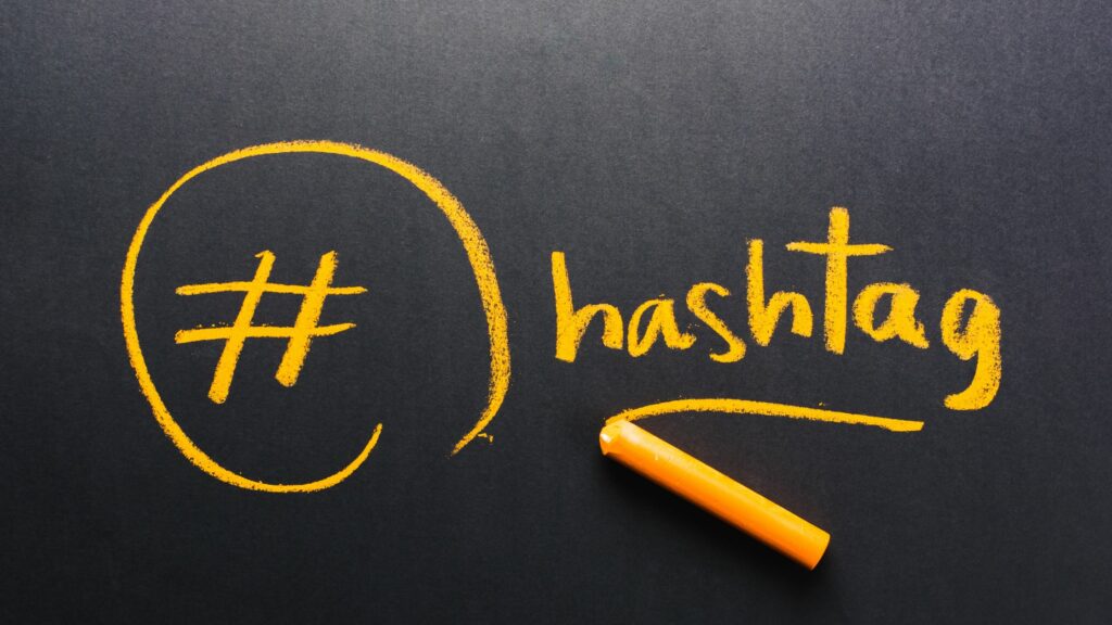 The word hashtag written on chalkboard in orange