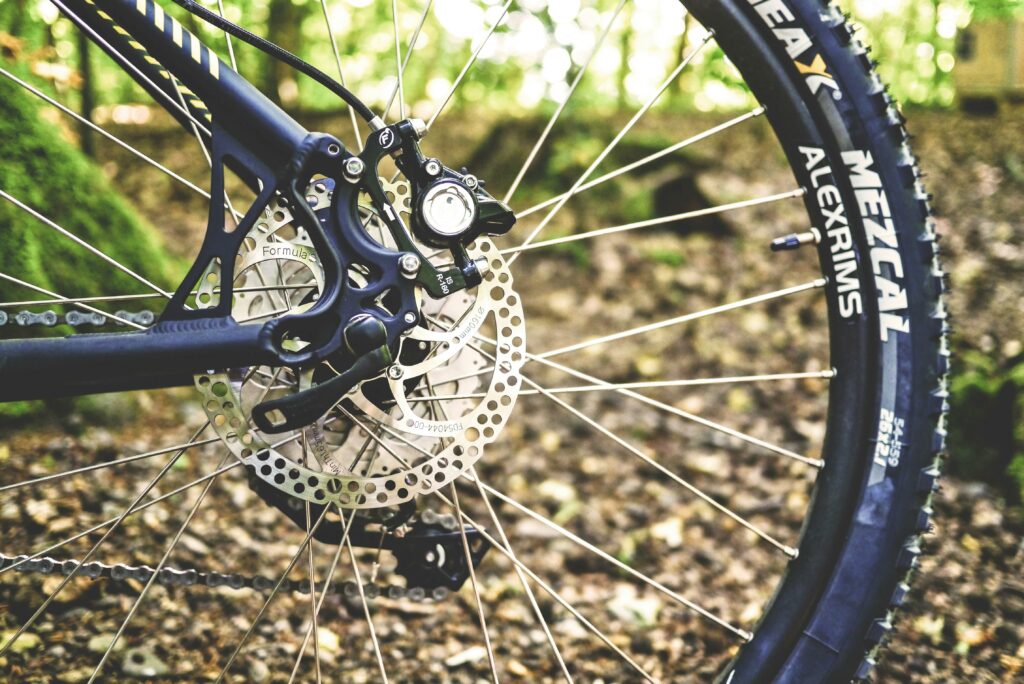 Image of a mount bike wheel on leafy ground.